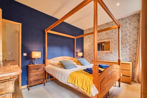 a bedroom with a canopy bed and blue walls at Jacuzzi Sauna Terrasse Venosc in Les Deux Alpes