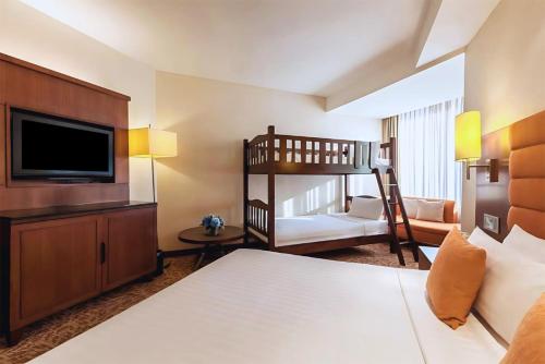 a hotel room with a bunk bed and a bedroom with a bunk bed at Rembrandt Hotel Bangkok in Bangkok