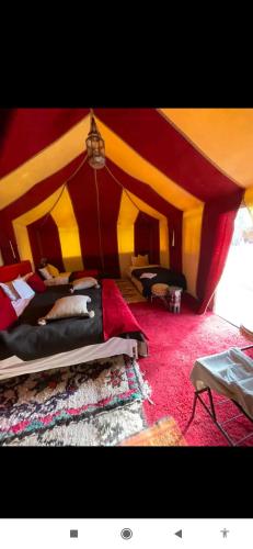 a room with a red and yellow tent at Berber Camp Merzouga in Merzouga