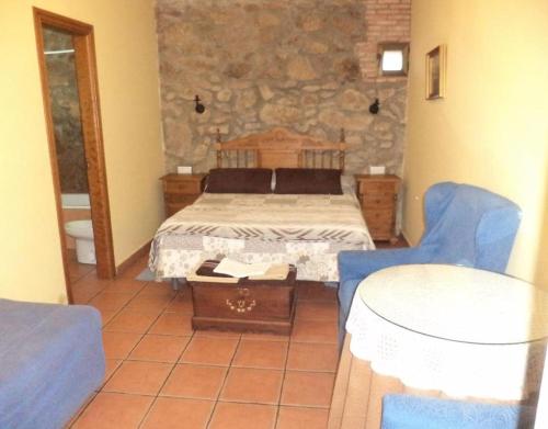 a bedroom with a bed and two blue chairs at Mansió De La Plata in Peñacaballera