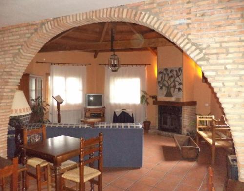 an archway in a living room with a table and a fireplace at Mansió De La Plata in Peñacaballera