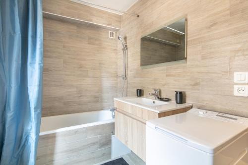 une salle de bain avec un lavabo, des toilettes et une baignoire dans l'établissement Le Saint-Geoirien - Duplex pour 4, à Merlas