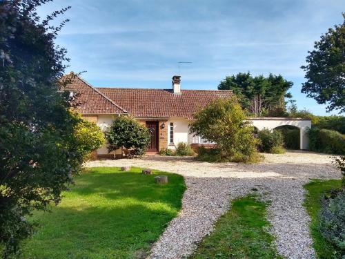 a house with a gravel driveway in front of it at Barton Lodge in Minehead