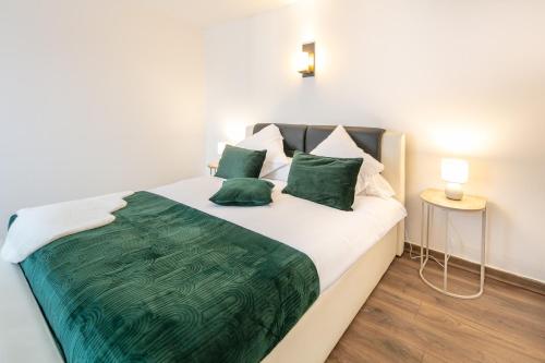 - une chambre dotée d'un grand lit avec des draps et des oreillers verts dans l'établissement Le Saint-Geoirien - Duplex pour 4, à Merlas