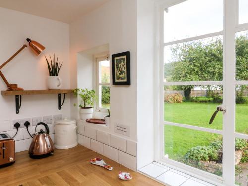 a kitchen with a window looking out at a yard at Barton Lodge in Minehead