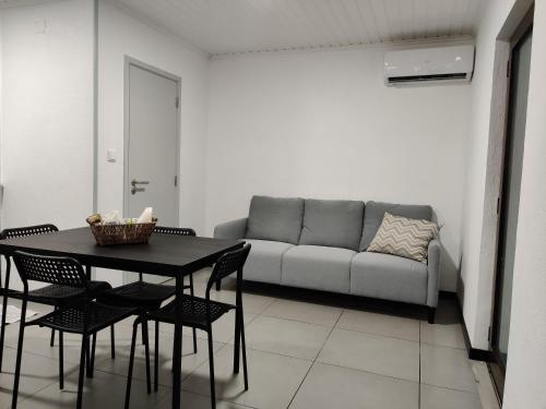 a living room with a couch and a table and chairs at Ocean View Cedros in Santa Cruz das Flores
