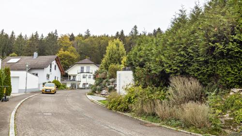 a yellow car driving down a street with houses at Ferienwohnung am Donauradweg in Tuttlingen