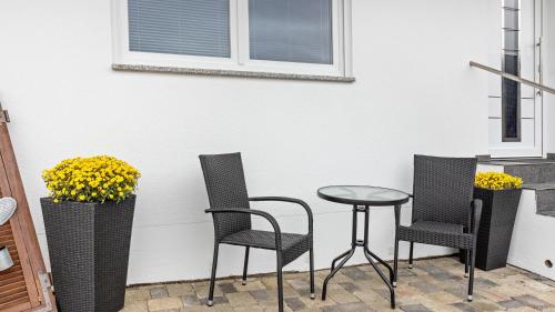 a patio with three chairs and a table at Ferienwohnung am Donauradweg in Tuttlingen
