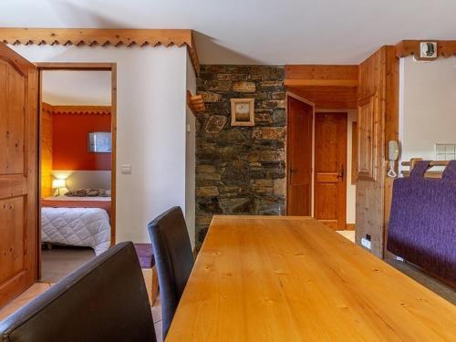 une salle à manger avec une table en bois et une chambre dans l'établissement Appartement charmant avec balcon, piscine & parking à Plagne Aime 2000 - FR-1-351-137, à Aime La Plagne