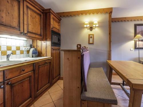 une cuisine avec des armoires en bois et une table en bois dans l'établissement Appartement charmant avec balcon, piscine & parking à Plagne Aime 2000 - FR-1-351-137, à Aime La Plagne
