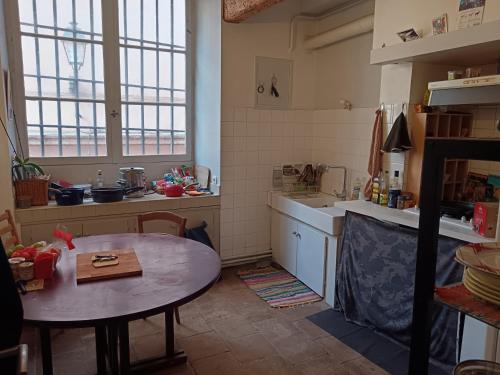 une cuisine avec une table et une petite table. dans l'établissement Appartement centre Toulouse, à Toulouse
