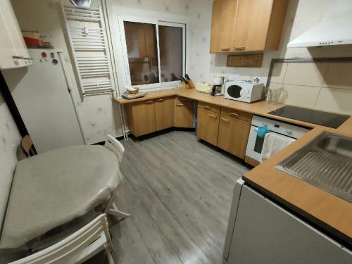 une petite cuisine avec un évier et un réfrigérateur dans l'établissement Appartement à 5min du centre ville d'Embrun, à Embrun