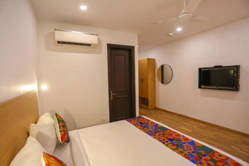 a bedroom with a bed and a flat screen tv at FabHotel Moro Paschim Vihar in New Delhi