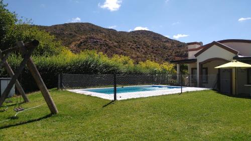 a swimming pool in a yard next to a house at Sol y Paz Valle Grande San Rafael in San Rafael