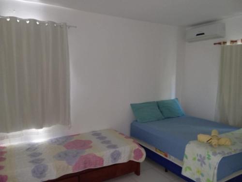 a bedroom with two beds and a window at Recanto do Angelo in Salvador