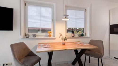 a kitchen with a wooden table and two chairs at Ferienwohnung Heidegarten in Radolfzell am Bodensee