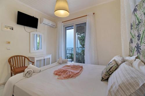 a bedroom with a large white bed with a window at S6 apartment in Nikiana
