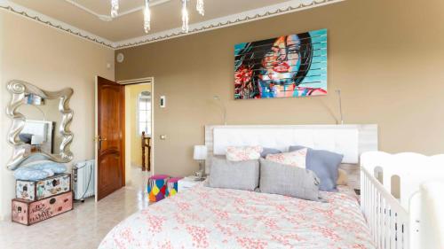 a bedroom with a bed and a painting on the wall at Chalet Luxury in Candelaria