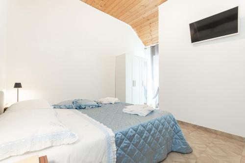 a white bedroom with a bed with a blue blanket at Parcheggio Gratis - 10min Aeroporto - Vista Mare in Genova