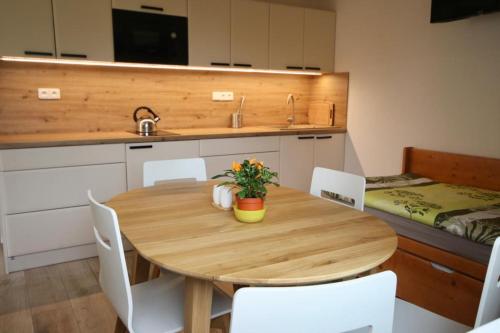 a kitchen with a wooden table and white chairs at Kemp na Zálabí in Vědomice