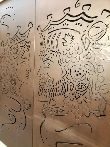 a drawing of two faces on a metal wall at B&B Sbarco dei 1000 Marsala in Marsala