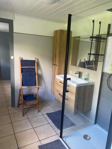 La salle de bains est pourvue d'un lavabo, d'une chaise et d'un miroir. dans l'établissement Gîte Au café des marguerites, à Plounévez-Lochrist