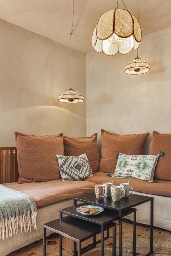 - un salon avec un canapé brun et 2 tables dans l'établissement Les Gîtes de l'Atelier - Gîtes de charme en Forêt de Fontainebleau - 1 Gîte 1 chambre et 1 Gîte 2 chambres, à Saint-Martin-en-Bière