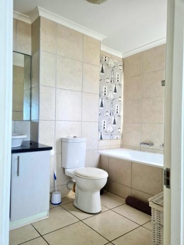 a bathroom with a toilet and a tub and a sink at Point Village Accommodation - Linda in Mossel Bay