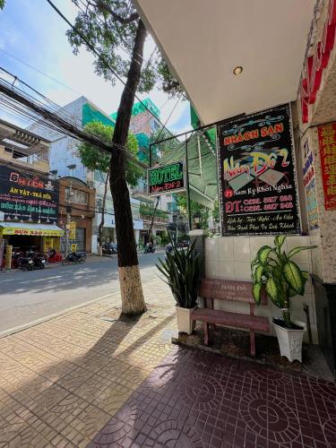 a bench sitting on a sidewalk next to a street at Nam Đô Hotel Cần Thơ Downtown in Can Tho
