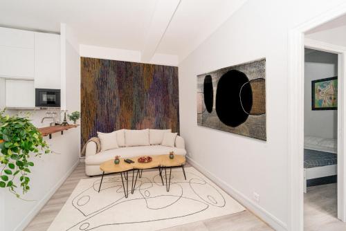 - un salon blanc avec un canapé blanc et des peintures dans l'établissement Opéra-Galeries, à Paris