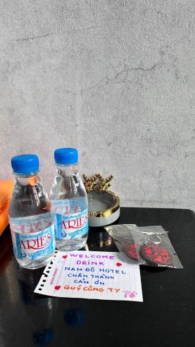 two bottles of water sitting on top of a table at Nam Đô Hotel Cần Thơ Downtown in Can Tho