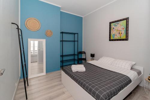 une chambre avec un lit et un mur bleu dans l'établissement Opéra-Galeries, à Paris