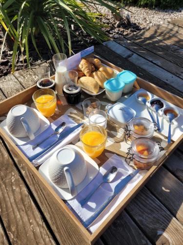 a tray of food with plates and utensils on a table at LeMasBlanc, Chambre d'hôtes & jacuzzi privé, au calme, 15min de Carcassonne in Malves-en-Minervois