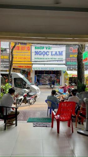 a group of people sitting in chairs in front of a store at Nam Đô Hotel Cần Thơ Downtown in Can Tho