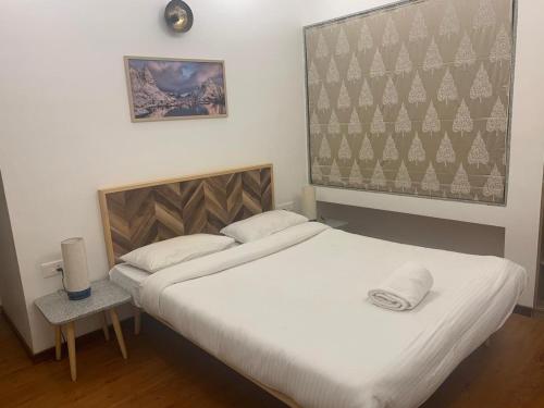 a bedroom with a large bed with white sheets at Mizzle Exotica Lonavala in Lonavala