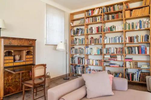 a living room with a couch and a book shelf filled with books at Luxus Villa mit großem Pool Alleinlage Nähe Graz in Erbersdorf
