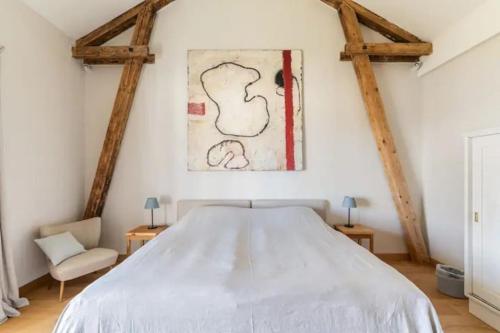 a bedroom with a white bed and a painting on the wall at Luxus Villa mit großem Pool Alleinlage Nähe Graz in Erbersdorf