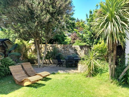 a garden with two chairs and a table and trees at PENINSULAR HOUSE in Camaret-sur-Mer