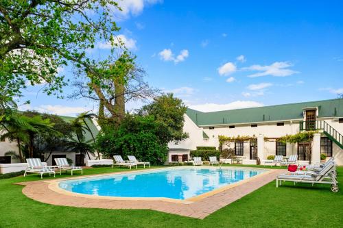 a swimming pool in the yard of a house at The Cellars-Hohenort in Cape Town
