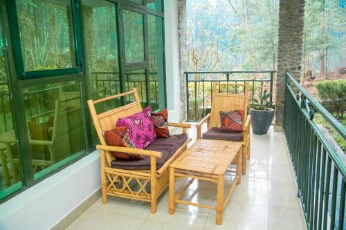 a porch with two chairs and a table at Karisimbi Cave Resort in Ruhengeri