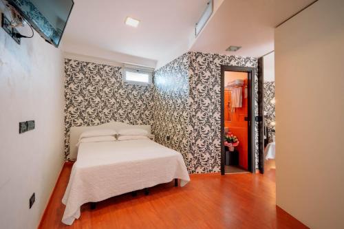 a bedroom with a bed in a room with a wall at Hotel Villa Marina Wellness SPA in Rimini