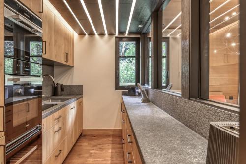 une cuisine avec des placards en bois et une grande fenêtre dans l'établissement Appartement Oberland, à Megève