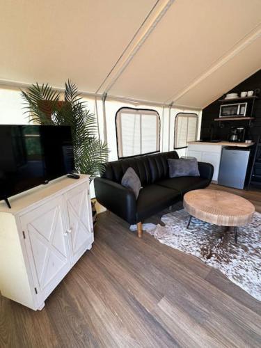a living room with a couch and a flat screen tv at Entire Glamping Campground, 8 Luxury Safari Tents in Cadiz