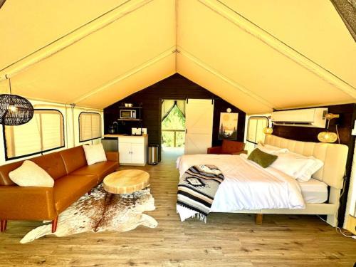 a bedroom with a bed and a couch and a table at Entire Glamping Campground, 8 Luxury Safari Tents in Cadiz