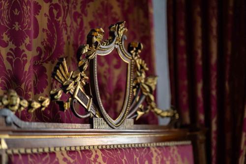 a gold mirror sitting on top of a table at Foresteria del Castello di San Giorgio Canavese in San Giorgio Canavese
