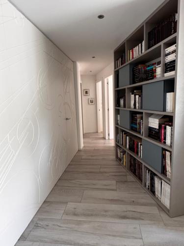 a hallway with bookshelves and a wall with books at La Riviera in Corseaux