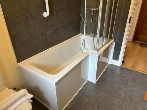 a bathroom with a shower and a white bath tub at 1 Coopers Cottage, Bodiam, East Sussex in Bodiam