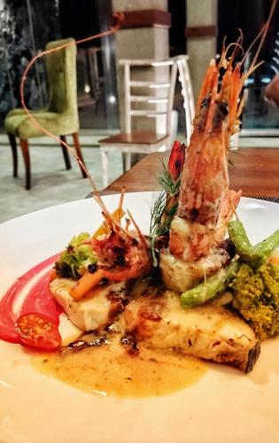 a plate of food with shrimp and vegetables on a table at Adique's Resorts in Marawila