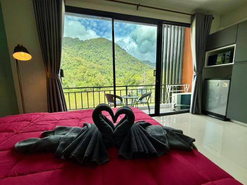 a bedroom with two black towels in the shape of a heart at TN KAMALA Room For Rent in Kamala Beach