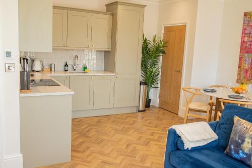 a kitchen and a living room with a blue couch at Charles Hope Salisbury Centre in Salisbury